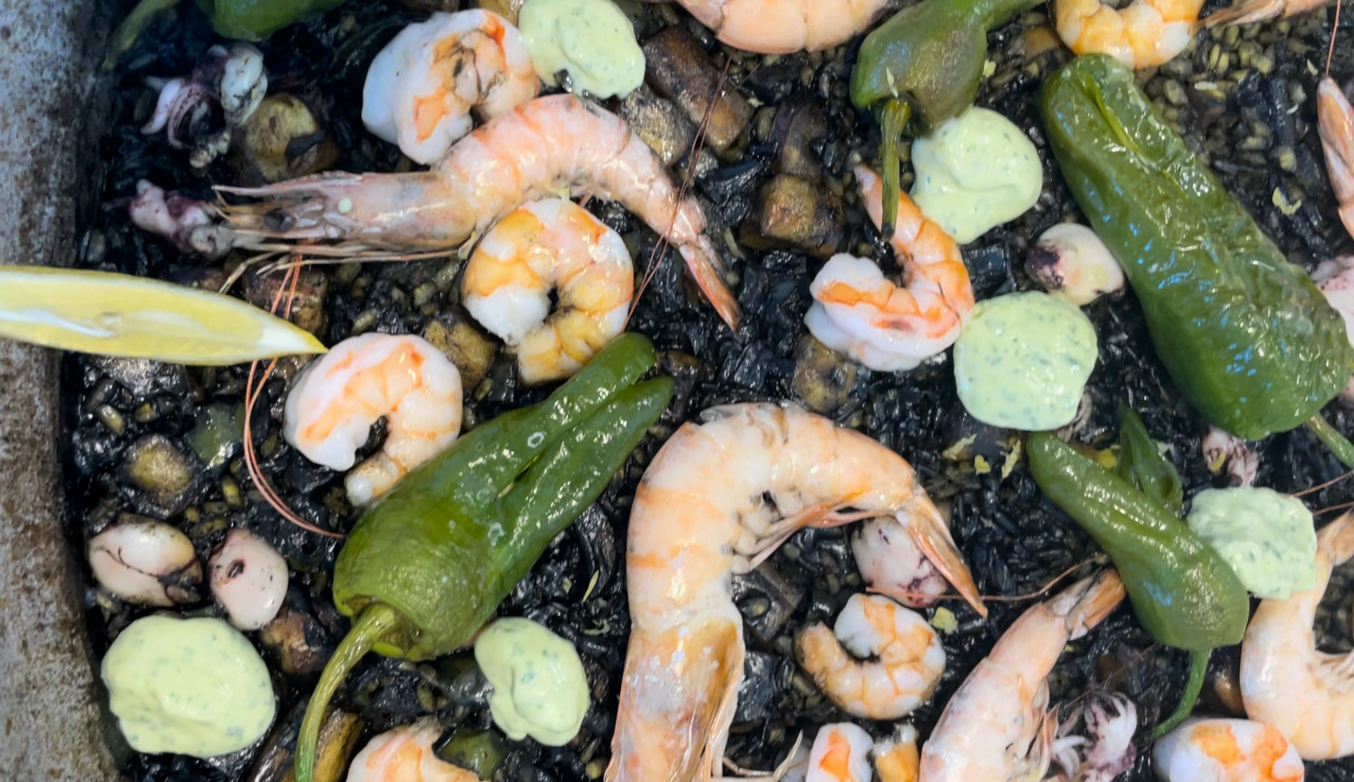 Decorando arroz negro con salsa de alioli de cilantro.