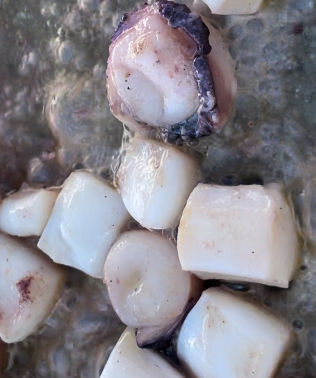 Comienzo del sofrito de calamar para paella de arroz negro