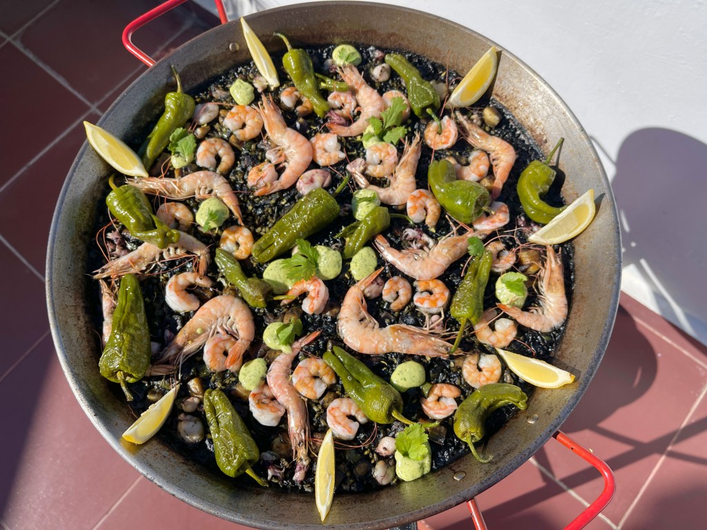 Arroz negro en paella con tinta de calamar y marisco
