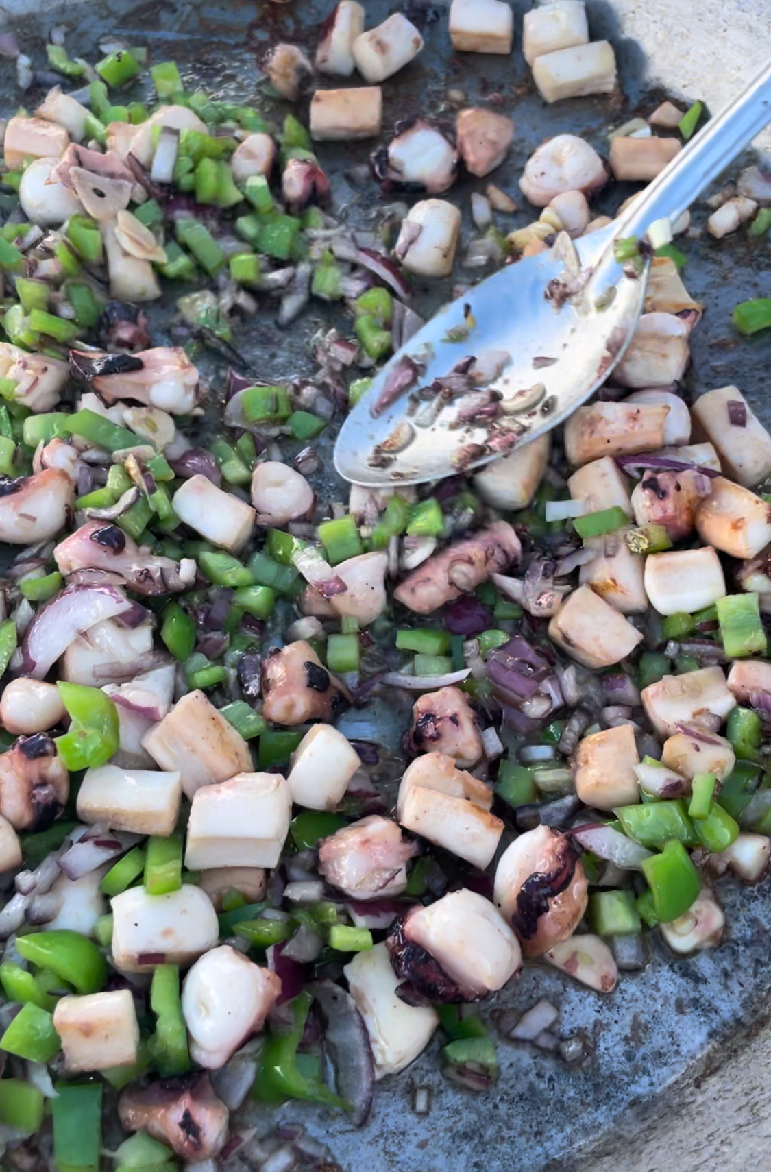 Calamares, tentaculos, pimiento verde y cebolla para sofrito de arroz negro.