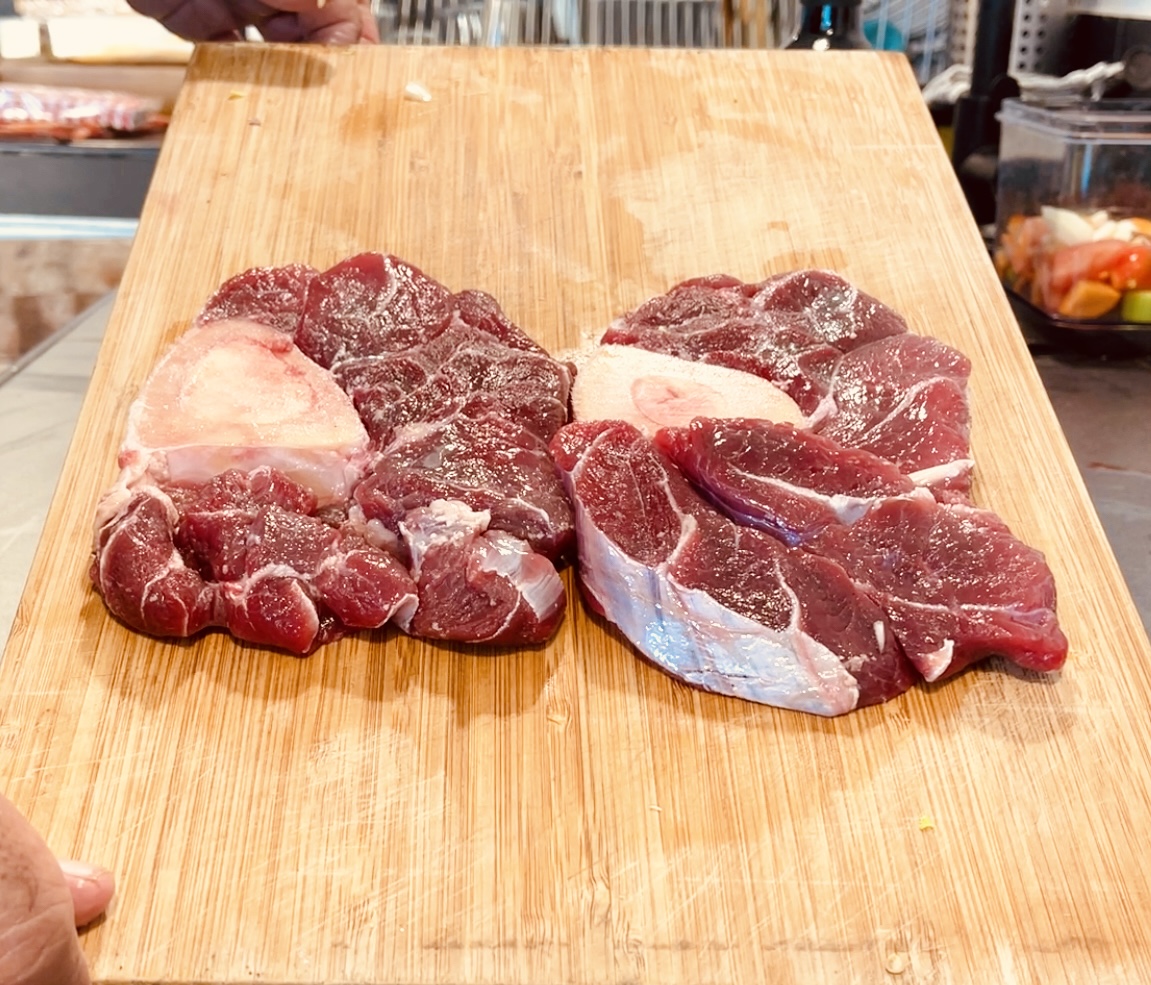 Osobuco crudo sobre tabla de corte de madera.